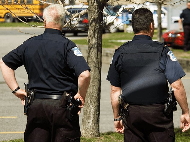 Two uniformed police officers standing watch outdoors